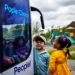 a group of kids standing next to a bus